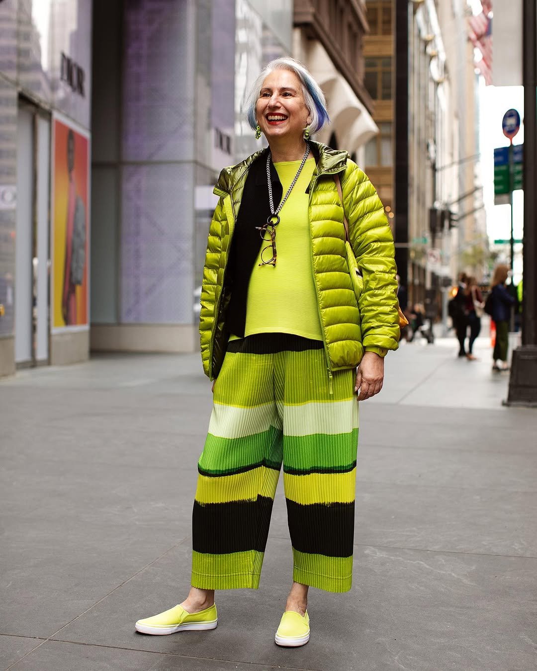 A vivid lime puffer jacket is layered over ribbed neon separates with striped wide-leg cropped pants and matching slip-on shoes.