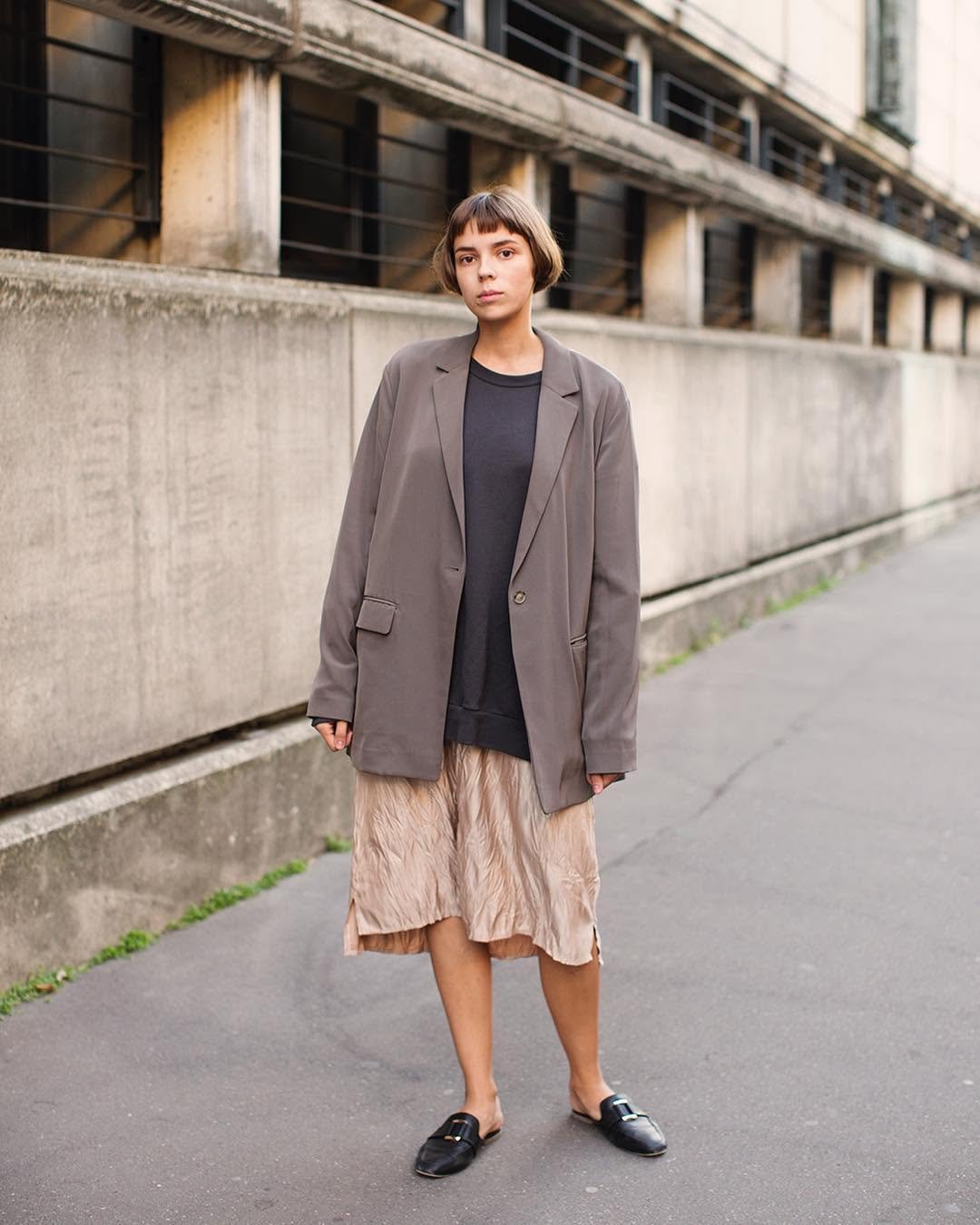 A photographed outfit: grey blazer, dark top, satin skirt and black loafers.